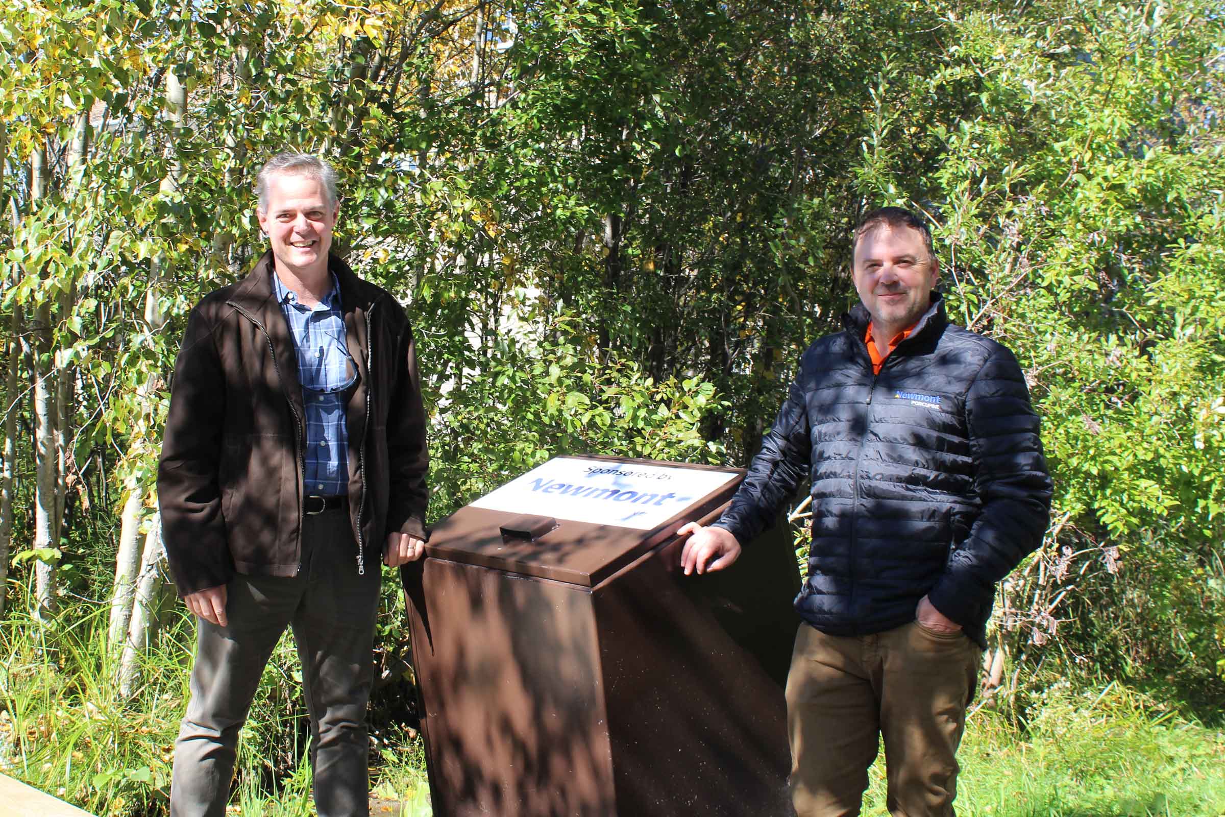 MRCA and Newmont representatives standing near a bear proof garbage bin